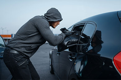 Huppupäinen mies ryöstämässä nahkalaukkua mustan auton ikkunasta